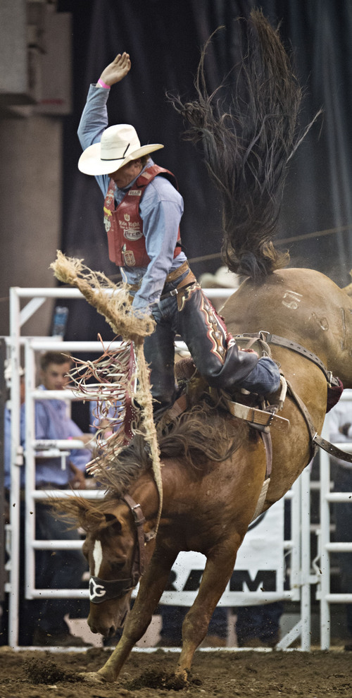 Lennie Mahler  |  The Salt Lake Tribune
Spencer Wright is launched from the horse in the saddle bronc riding event of the Days of '47 Rodeo at EnergySolutions Arena, Friday, July 25, 2014.