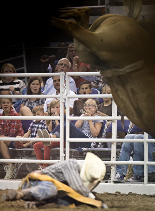 Lennie Mahler  |  The Salt Lake Tribune
Fans watch as Ethan McNeil falls off the horse in the bareback bronc riding event of the Days of '47 Rodeo at EnergySolutions Arena, Friday, July 25, 2014.