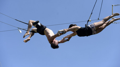 Al Hartmann  |  The Salt Lake Tribune 
Utah Flying Trapeze is open at the the south side of Pioneer Park Wednesday July 23.  Rachel Juozapaitis, right, makes a succesful grab by "catcher" Nick Glomb, a co-owner of the trapeze.   A trapeze set complete with safety harnesses, nets and instruction will be offered to the public throughout weekdays by the Utah Flying Trapeze group.