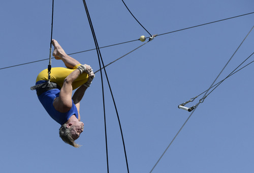 Al Hartmann  |  The Salt Lake Tribune 
Utah Flying Trapeze is open at the the south side of Pioneer Park Wednesday July 23.  Dennis Ford of Scottsdale, AZ , does a flipping dismount from the bar.   A trapeze set complete with safety harnesses, nets and instruction will be offered to the public throughout weekdays by the Utah Flying Trapeze group.