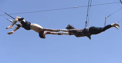 Al Hartmann  |  The Salt Lake Tribune 
Utah Flying Trapeze is open at the the south side of Pioneer Park Wednesday July 23.  Sarah Lyman of Salt Lake City, right, makes a succesful grab by "catcher" Nick Glomb, a co-owner of the trapeze.   A trapeze set complete with safety harnesses, nets and instruction will be offered to the public throughout weekdays by the Utah Flying Trapeze group.