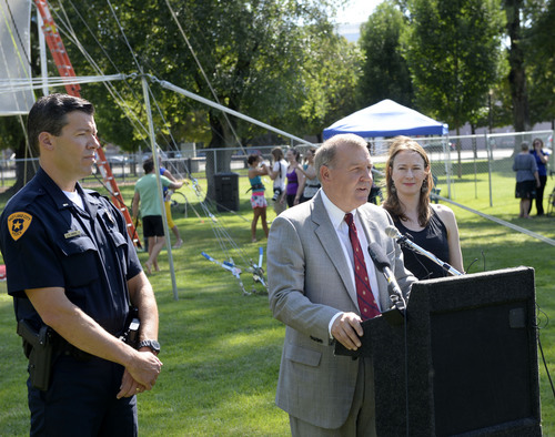 Al Hartmann  |  The Salt Lake Tribune 
Salt Lake City Police Dept. Lt, Rich Brady, left, and Rick Graham, Public Services Department Director welcomes the Utah Flying Trapeze to the south end of Pioneer Park Wednesday July 23.  A trapeze set complete with safety harnesses and nets will be offered to the public throughout weekdays by the Utah Flying Trapeze group.  It's part of a concerted effort by the city to help make the park a safe place with activities like the concerts and the farmers market.