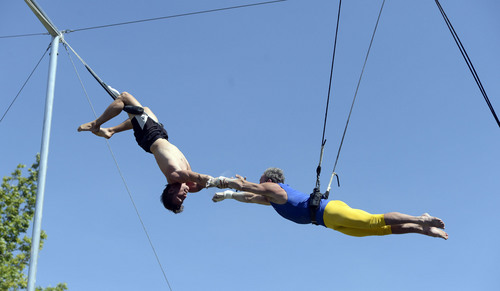 Al Hartmann  |  The Salt Lake Tribune 
Utah Flying Trapeze is open at the the south side of Pioneer Park Wednesday July 23.  Dennis Ford of Scottsdale, AZ , right, misses a two-hand grab from "catcher" Nick Glomb, a co-owner of the trapeze.   A trapeze set complete with safety harnesses, nets and instruction will be offered to the public throughout weekdays by the Utah Flying Trapeze group.