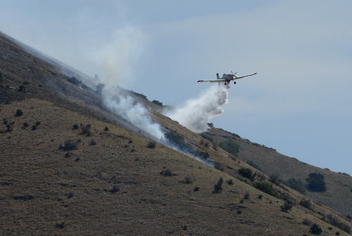 Scott Sommerdorf   |  The Salt Lake Tribune
A firefighting cropduster drops its water onto hotspots in the hills east of Springville, Saturday, July 26, 2014.