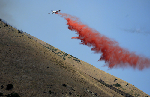Scott Sommerdorf   |  The Salt Lake Tribune
A crop duster drops it's cargo of fire retardant in the hills east of Springville, Saturday, July 26, 2014.