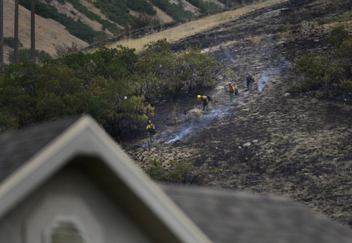 Scott Sommerdorf   |  The Salt Lake Tribune
Fire crews on foot work to clean up hotspots in the hills east of Springville on Saturday.