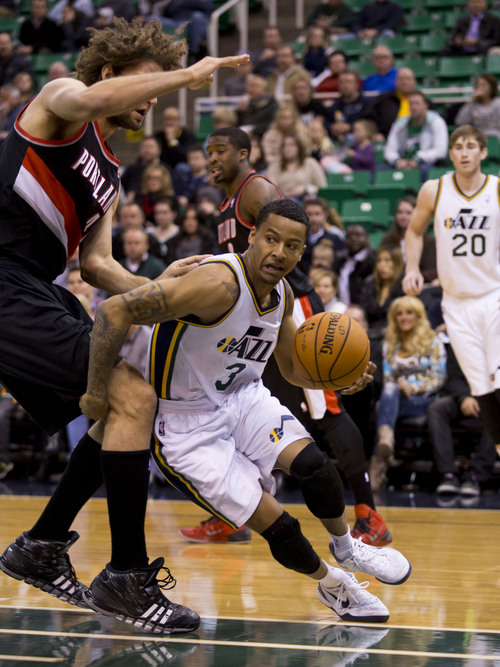 Lennie Mahler  |  The Salt Lake Tribune
Jazz guard Trey Burke looks to pass the ball as he drives around Portland's Robin Lopez in the first half of a game against the Portland Trailblazers on Monday, Dec. 9, 2013.
