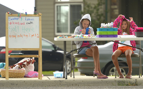 Leah Hogsten  |  The Salt Lake Tribune
The rain has been bothering us," said Libbie Miles, "it ruins business." Sisters Libbie Miles, 13, (left) and Brooklyn Miles, 7, set up shop outside their home to sell "sillyband" crafts the two had made, July 29, 2014.