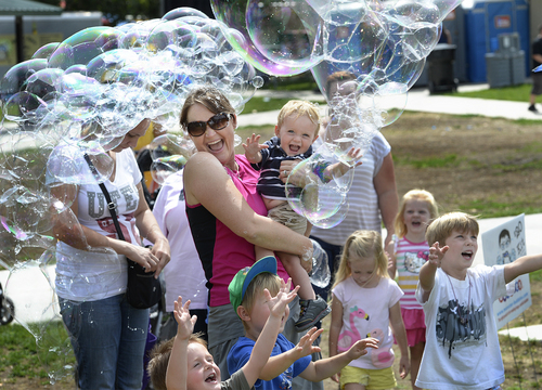 Scott Sommerdorf   |  The Salt Lake Tribune
Rebecca Ireland with her son Keegan, 15 months, enjoys the bubble-making of Arnold Berg at his Monster Bubbles booth at the Wasatch Front Farmers Market at Wheeler Historic Farm, Sunday, August 3, 2014.