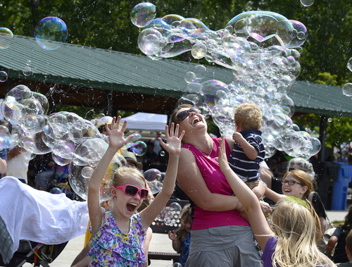 Scott Sommerdorf   |  The Salt Lake Tribune
Rebecca Ireland with her son Keegan, 15 months, enjoys the bubble-making of Arnold Berg with others at his Monster Bubbles booth at the Wasatch Front Farmers Market at Wheeler Historic Farm, Sunday, August 3, 2014.