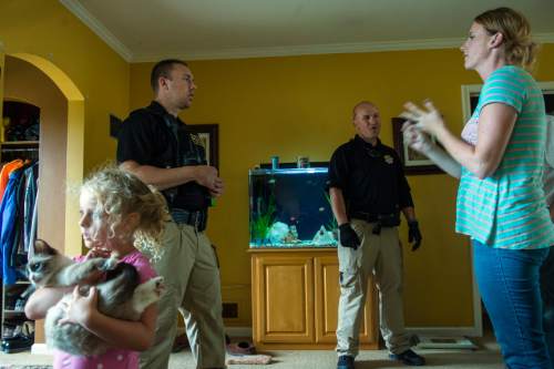 Chris Detrick  |  The Salt Lake Tribune
Adult Probation and Parole agent Chris Moore, left, and Assistant Regional Administrator Nathan Griffiths talk with probationer Melina Rowley Bunch, 28, during an unscheduled visit at her home in Salt Lake City Thursday July 31, 2014.