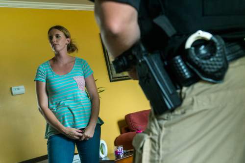 Chris Detrick  |  The Salt Lake Tribune
Adult Probation and Parole agent Chris Moore talks with probationer Melina Rowley Bunch, 28, during an unscheduled visit at her home in Salt Lake City Thursday July 31, 2014.