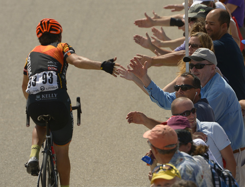 Leah Hogsten  |  The Salt Lake Tribune
 Fans slap the hand of a Optum P/B Kelly Benefit Strategies team member after 2014 Tour of Utah cyclists end the day at Miller Motorsports Park during Wednesday's 118.3-mile stage, August 6, 2014.
