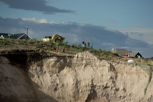 Jeremy Harmon  |  The Salt Lake Tribune

People are seen at the top of an area damaged by a landslide in North Salt Lake on Tuesday, August 5, 2014. A home at the bottom of the slide was destroyed.