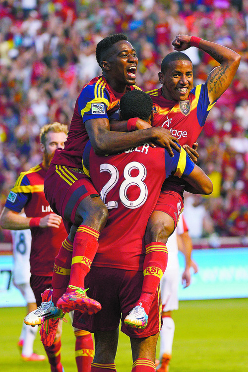 Real Salt Lake forwards Olmes Garcia (13) and Joao Plata (8) jump into the arms of defender Chris Schuler (28) after one of Schuler's two goals during the first half of an MLS soccer game against DC United, Saturday, Aug. 9, 2014, in Sandy, Utah. (AP Photo/The Salt Lake Tribune, Leah Hogsten) DESERET NEWS OUT; LOCAL TELEVISION OUT; MAGAZINES OUT