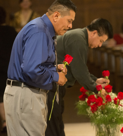 Rick Egan  |  The Salt Lake Tribune

Remigio Moran, on left, a member of Sts. Peter and Paul Parish in West Valley City, places roses during the Mass and Blessing of Lay Ecclesial Ministers at the Cathedral of the Madeleine on Aug. 9, 2014.  Moran was one of 85 lay Catholics  commissioned Saturday by Bishop John Wester.