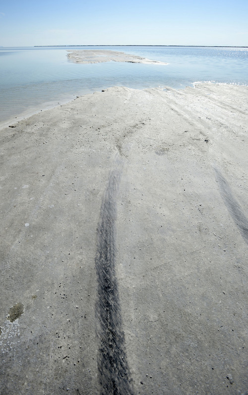 Al Hartmann  |  The Salt Lake Tribune 
Tire tracks disappear from salt into three or four inches of water at the Bonneville Salt Flats Monday August 11, 2014.  Water covers the normally dry salt flats from rains last week putting an end to "Speed Week."