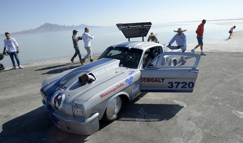 Al Hartmann  |  The Salt Lake Tribune 
Todd Landon from MInneapolis pushes his Mustang race car on the access road where pavement ends and salt begins at the Bonneville Salt Flats Monday August 11, 2014. He parked it there to at least get some video and photos of the car.  Three or four inches of water covers the salt flats from rains last week putting an end to "Speed Week."