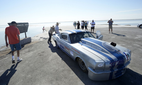 Al Hartmann  |  The Salt Lake Tribune 
Todd Landon from MInneapolis pushes his Mustang race car on the access road where pavement ends and salt begins at the Bonneville Salt Flats Monday August 11, 2014. He parked it there to at least get some video and photos of the car. No racing this week.  Three or four inches of water covers the salt flats from rains last week putting an end to "Speed Week."