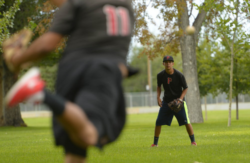 Leah Hogsten  |  The Salt Lake Tribune
l-r Brothers Humberto and Carlos Medina practice passing Tuesday, August 12, 2014, in Rose Park. Humberto is a pitcher for University of Arkasas and Carlos plays catcher at West High. The two say they pass ball 2-3 times a week and learned to love the game from their family in Mexico.