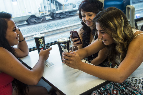 Chris Detrick  |  The Salt Lake Tribune
Arianna Garcia, Angel Garcia and Yazmen Ablia, use the free Wi-Fi on their phones while riding UTA 's FrontRunner to Salt Lake City Tuesday July 29, 2014.