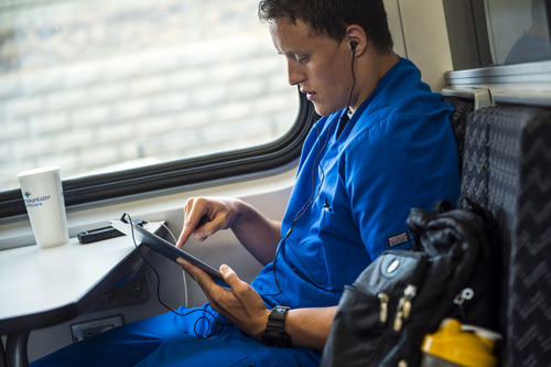 Chris Detrick  |  The Salt Lake Tribune
Mitch Newey, of Ogden, uses the free Wi-Fi on his tablet while riding UTA's FrontRunner to Ogden from Salt Lake City Tuesday July 29, 2014.