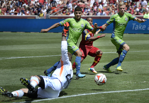 Scott Sommerdorf   |  The Salt Lake Tribune
RSL forward Joao Plata watches between DeAndre Yedlin and Andy Rose as Luke Mulholland's shot rolls past Seattle goalkeeper Stefan Frei early in the second half for a 2-0 lead. RSL defeated the Seattle Sounders 2-1 at Rio Tinto Stadium, Saturday, August 15, 2014. The goal was listed as an "own goal" on Seattle's Osvaldo Alonso.