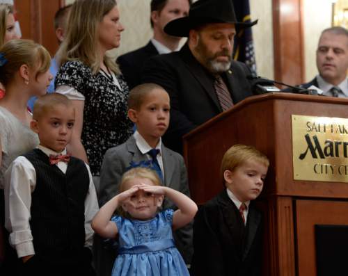 Scott Sommerdorf   |  The Salt Lake Tribune
Rick Koerber speaks at a news conference supported by family. His daughter Bethany is at far left, two adopted sons, Erick and Samuel in the foreground, and his wife Jewel Skousen holds their daughter Annastasia the day after a federal judge tossed out 18 charges against Koerber that had alleged he operated a giant Ponzi scheme through his real estate company, Friday, August 15, 2014. Attorney Marcus Mumford is at far right.