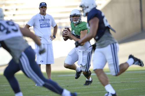 Chris Detrick  |  The Salt Lake Tribune
Brigham Young Cougars quarterback Taysom Hill (4) looks to pass the ball as Brigham Young Cougars head coach Bronco Mendenhall looks on during a scrimmage at LaVell Edwards Stadium Friday August 15, 2014.