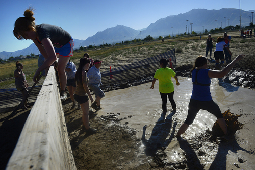 Scott Sommerdorf   |  The Salt Lake Tribune
Runners scale an obstical before dropping into a mud pit during the Kiss Me Dirty Mud Run - raising money for a good cause -- gynecological cancer research on Saturday.