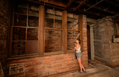 Francisco Kjolseth  |  The Salt Lake Tribune
Eiya Jennifer McDaniel, a design and colorist specialist, shines a light into a small room with windows in the basement of the Zim's building at 150 S. Main St. Zim's, one of Salt Lake City's oldest commercial buildings, originally opened in 1896 and is being renovated. The basement where carriages were once manufactured reveals some of the most interesting details of its historic past.