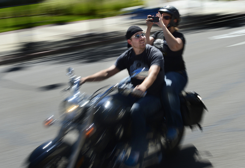 Scott Sommerdorf   |  The Salt Lake Tribune
A rider's passenger takes photos from the back of his cycle during a motorcycle ride to commemorate fallen officers that began at the Timpanogos Harley-Davidson dealership and ended at the Utah State Capitol, Sunday, August 17, 2014.