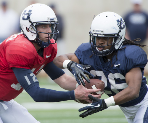Rick Egan  |  The Salt Lake Tribune

Utah State QB Craig Harrison (12) fakes a hand off to Kennedy Williams (26) in the Aggie's final spring scrimmage, Saturday, April 12, 2014