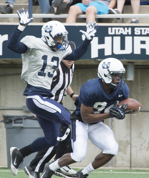 Rick Egan  |  The Salt Lake Tribune

Damoun Patterson (30) grabs a pass for the Blue team, as Ladale Jackson (13) defends, in the Utah State Aggie's final spring scrimmage, Saturday, April 12, 2014