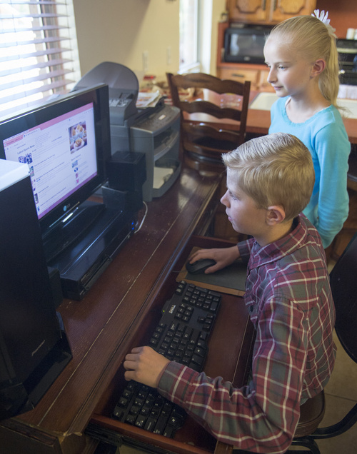 Rick Egan  |  The Salt Lake Tribune

Peter Hammon, 12, and Ivy Hammon 10, check out  the internet from their Riverton home, Monday, August 18, 2014. 
The Hammon family could not afford the internet without the special deal from Comcast.