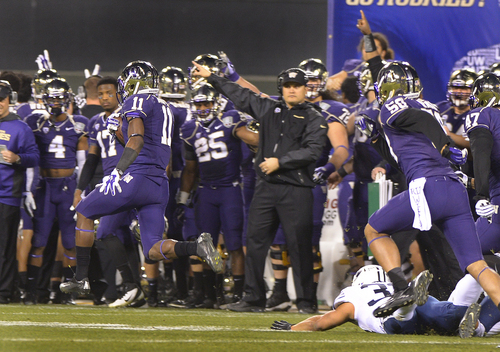 Scott Sommerdorf   |  The Salt Lake Tribune
Washington Huskies head coach Marques Tuiasosopo, center. motions as the sideline reacts to kick returner John Ross as he returns a BYU kickoff 100 yards for a TD during first half play at the Fight Hunger Bowl at AT&T Park in San Francisco, Friday December 27, 2013.