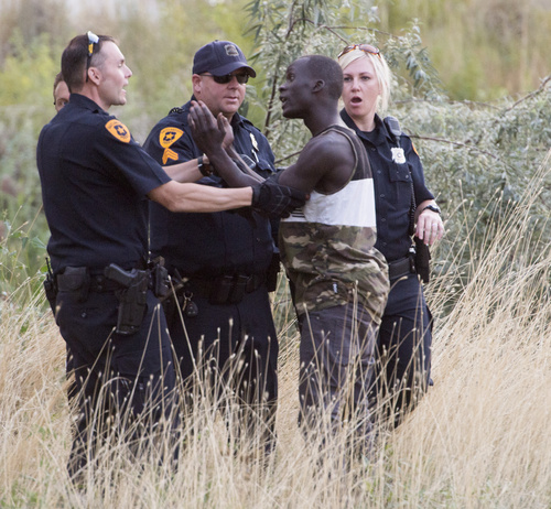 Rick Egan  |  The Salt Lake Tribune

Police try to calm a man reported to be the brother of the suspect as he confronts them about why they shot his brother, who was still in the Jordan River, Saturday, August 23, 2014. The man jumped into the river while being pursued by the police and held onto a branch for nearly two hours before the police were able to remove him.