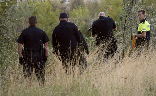 Rick Egan  |  The Salt Lake Tribune

Salt Lake City Police aim at the suspect, as they try to coax him to come out of the Jordan River, Saturday, August 23, 2014. The man jumped into the river while being pursued by the police and held onto a branch for nearly two hours before the police were able to remove him.