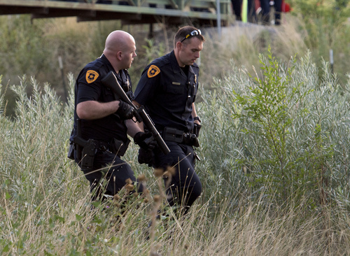 Rick Egan  |  The Salt Lake Tribune

Salt Lake City Police wait for the suspect to come out of the Jordan River, Saturday, August 23, 2014. The man jumped into the river while being pursued by the police and held onto a branch for nearly two hours before the police were able to remove him.