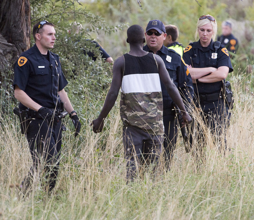 Rick Egan  |  The Salt Lake Tribune

Police try to calm a man reported to be the brother of the suspect as he confronts them about why they shot his brother, who was still in the Jordan River, Saturday, August 23, 2014. The man jumped into the river while being pursued by the police and hung onto a branch for nearly two hours before the police were able to remove him.