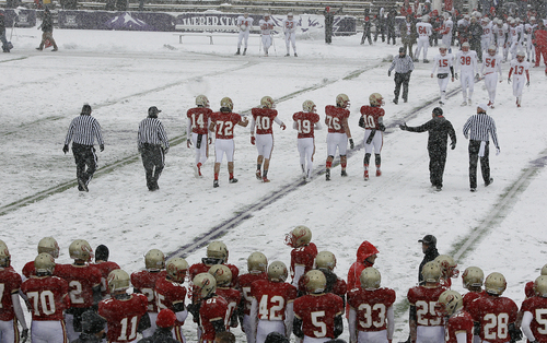 Scott Sommerdorf   |  The Salt Lake Tribune
Judge Memorial (in red) and Manti players walk out onto the snow covered turf to meet each other prior to kickoff in the 3A championship game played at Weber State University in Ogden, Utah, Saturday November 16, 2013..