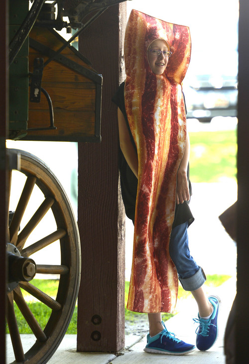 Leah Hogsten  |  The Salt Lake Tribune
Farm Country volunteer Sarah Craig, 11, greets visitors at  Thanksgiving Point. Thanksgiving Point celebrated all things pig, especially bacon, with its Bacon Bash, Saturday, August 23, 2014. The event included games and pony and wagon rides.