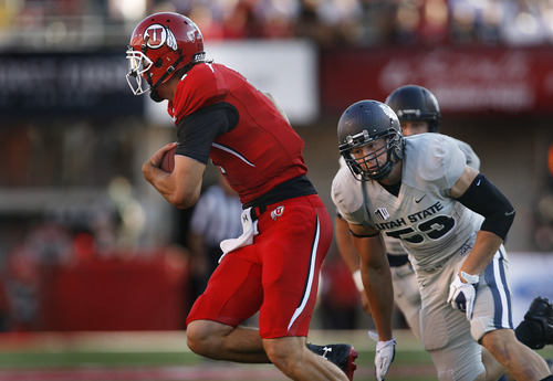 Scott Sommerdorf   |  The Salt Lake Tribune
Utah QB Travis Wilson runs for 10 yards, away from pressure from USU LB Zach Vigil who was flagged for 15 yards at the end of the play for a personal foul on Wilson. Utah later took a quick 7-0 lead over USU early in the 1st period, Thursday, August 29, 2013.