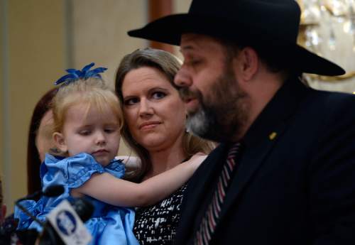 Scott Sommerdorf   |  The Salt Lake Tribune
Rick Koerber speaks as his wife Jewel Skousen holds their daughter Annastasia, 3, and listens as Koerber held a news conference the day after a federal judge tossed out 18 charges against him that had alleged he operated a giant Ponzi scheme through his real estate company, Friday, August 15, 2014.