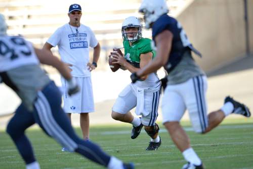 Chris Detrick  |  The Salt Lake Tribune
Brigham Young Cougars quarterback Taysom Hill (4) looks to pass the ball as Brigham Young Cougars head coach Bronco Mendenhall looks on during a scrimmage at LaVell Edwards Stadium Friday August 15, 2014.