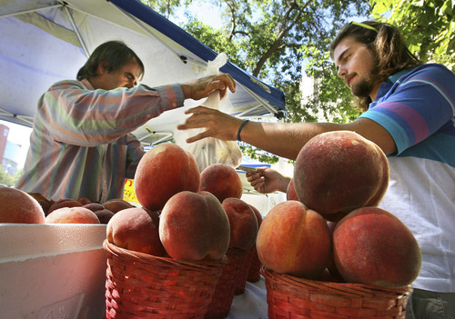 Scott Sommerdorf  |  Salt Lake Tribune file photo 
University of Utah student Geoffrey Strom, right, buys peaches from Ron Jensen of Ron Jensen Farms at the University of Utah's farmers market in 2008. This year's market kicks off Thursday and continues into October.