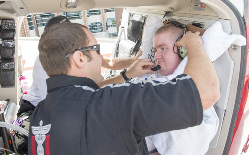 Rick Egan  |  The Salt Lake Tribune

Flight paramedic Jordan Fielding secures the head phones on Sean Anderson for his helicopter flight back to Stansbury Park, at the University of Utah Medical Center, Wednesday, August 27, 2014.  Sean was born with muscular dystrophy and is autistic. He loves hospitals, ambulances and helicopters. AirMed granted Sean's wish to fly in a helicopter.