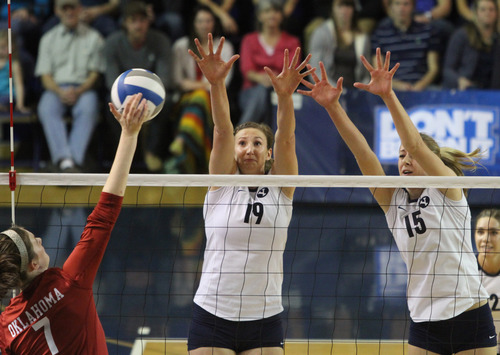 Rick Egan  | The Salt Lake Tribune 

Kierra Holst spikes the ball for the Oklahoma, as Jennifer Hamson (19) and Nicole Warner (15) defend for the Cougars, as BYU faced Oklahoma in NCAA  volleyball action at the Smith Fieldhouse in Provo, Saturday, December 1, 2012.