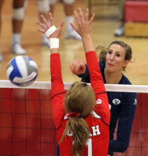 Rick Egan  | The Salt Lake Tribune 

Jennifer Hamson, 19, hits the ball over the net for BYU, as Chelsey Schofield, 11, defends for the Lady Utes, in volleyball action, Utah vs. BYU, in Salt Lake City, Saturday, September 10, 2011.