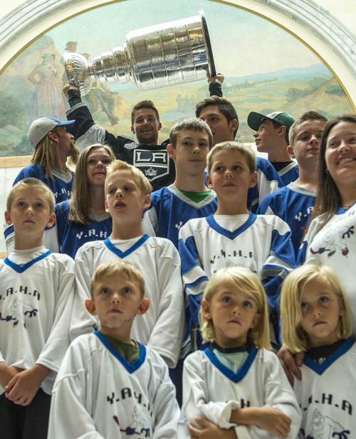 Chris Detrick  |  The Salt Lake Tribune
Los Angeles Kings' Trevor Lewis lifts up the Stanley Cup as he poses for pictures with YETI Youth Hockey team from Cedar City at the Utah State Capitol Wednesday August 27, 2014. Lewis is a Salt Lake City native who played for Brighton's club team as a freshman in 2002. Hockey tradition dictates that each member of the winning team gets custody of the Cup for one day.